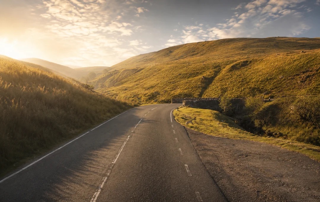 A winding road through the Black Mountain hills in golden evening light